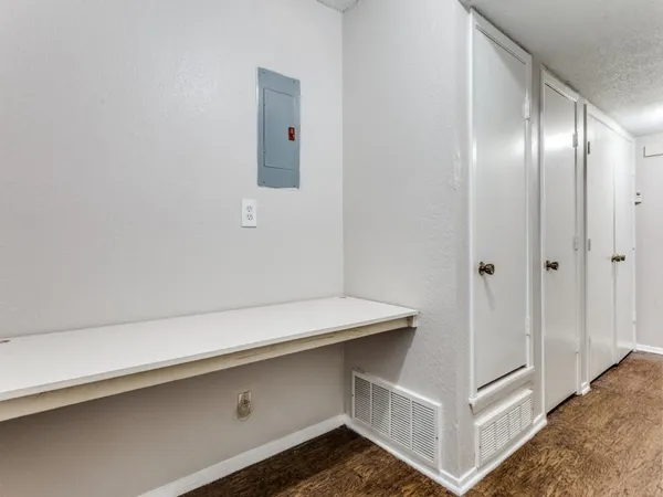 a hallway with white cabinets and wooden floor