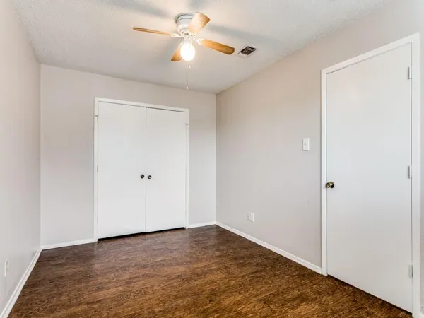 a view of a big room with wooden floor and a ceiling fan