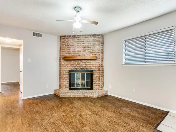 a view of an empty room with a fireplace and a window