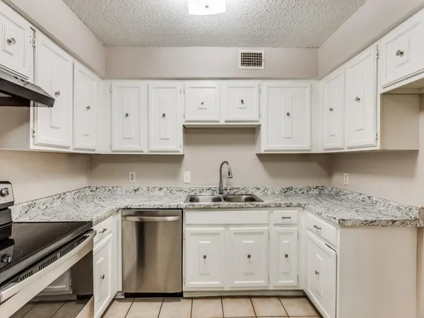a kitchen with granite countertop white cabinets and white appliances