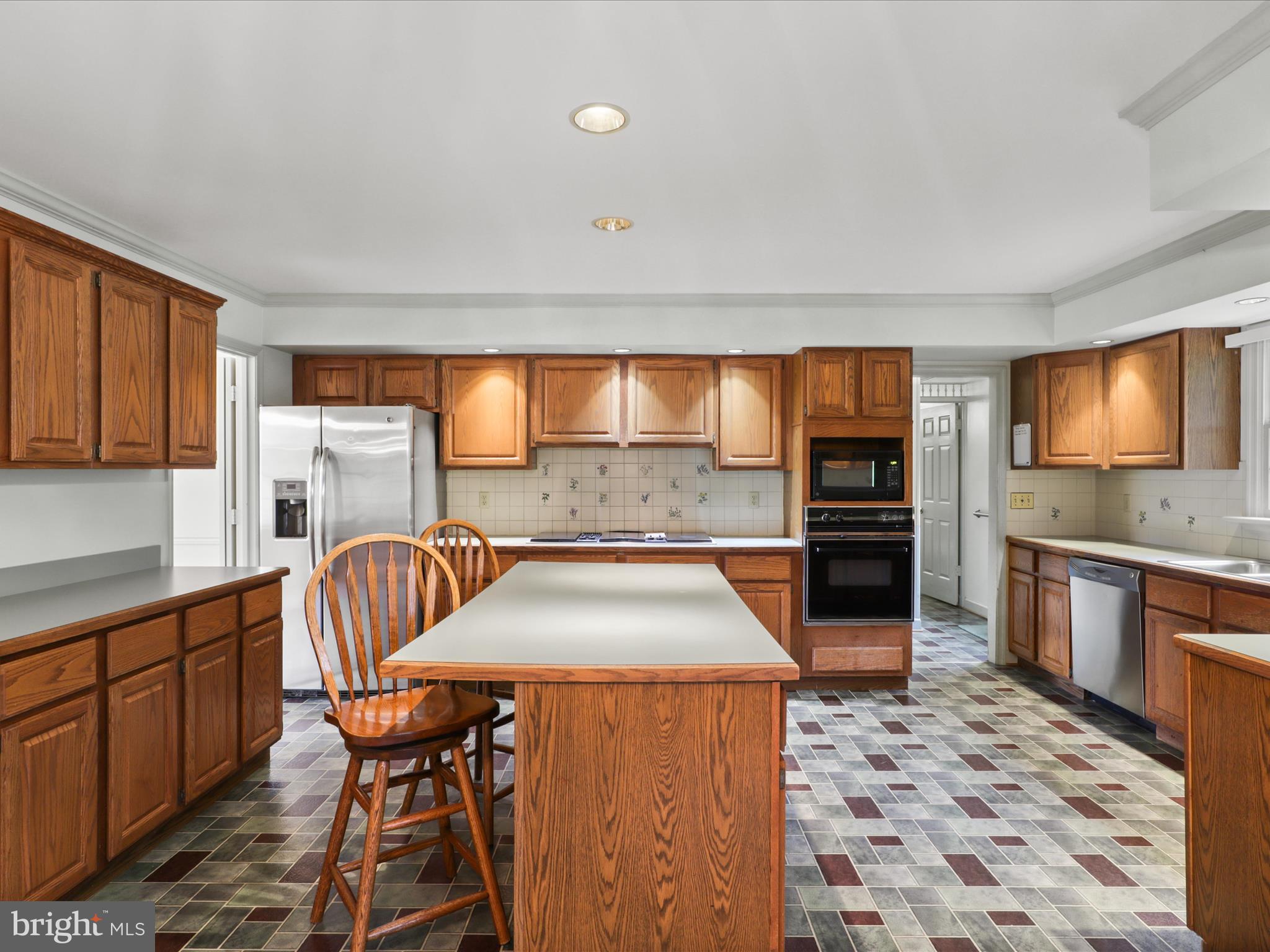 13124 South River Road Sumerduck, VA 22742 - Photo 13 of 54 a kitchen with stainless steel appliances kitchen island granite countertop a table chairs in it and wooden floors