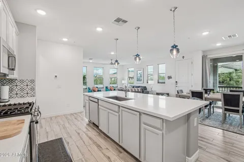 a large kitchen with kitchen island a stove a sink a center island and furniture