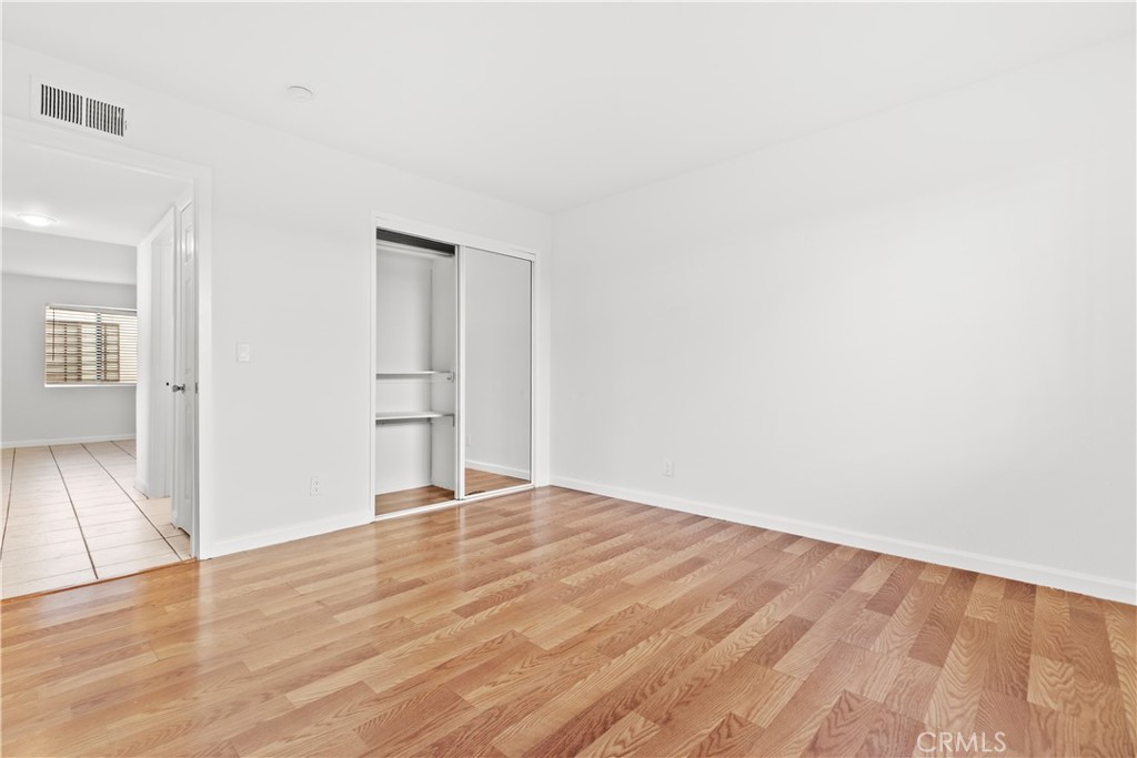 5915 Woodman Avenue, Unit 103 Van Nuys, CA 91401 - Photo 6 of 9 an empty room with wooden floor and windows