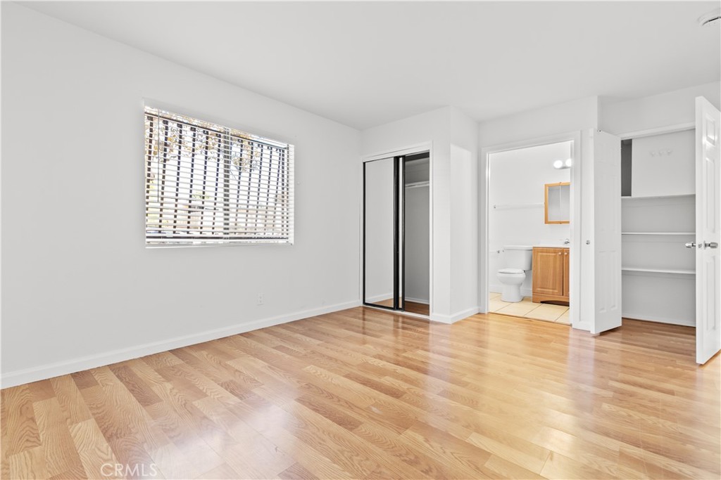 5915 Woodman Avenue, Unit 103 Van Nuys, CA 91401 - Photo 7 of 9 a view of an empty room with wooden floor and a window
