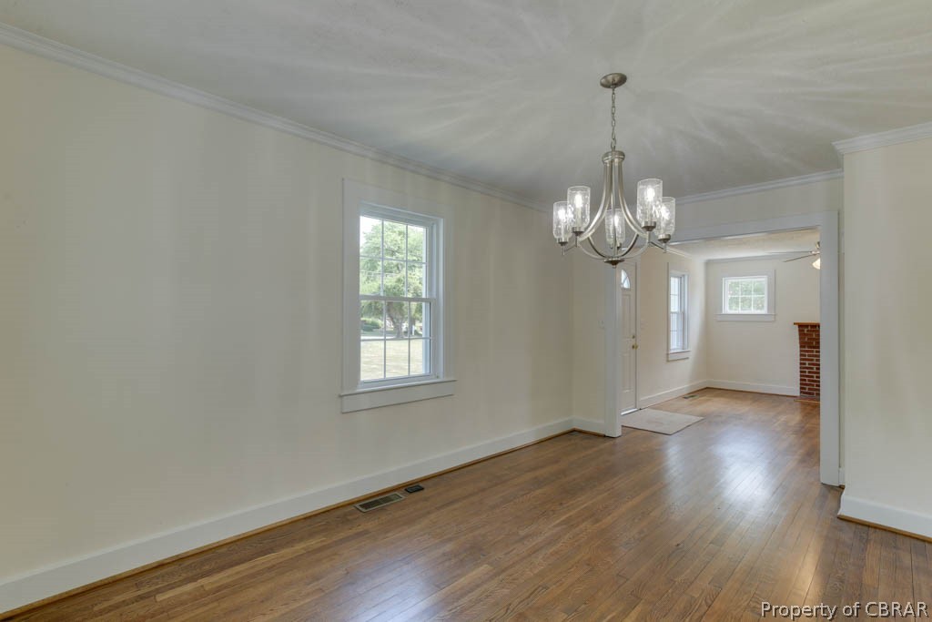 400 Showalter Road Yorktown, VA 23692 - Photo 13 of 49 Empty room featuring ceiling fan with notable chandelier, wood-type flooring, and crown molding