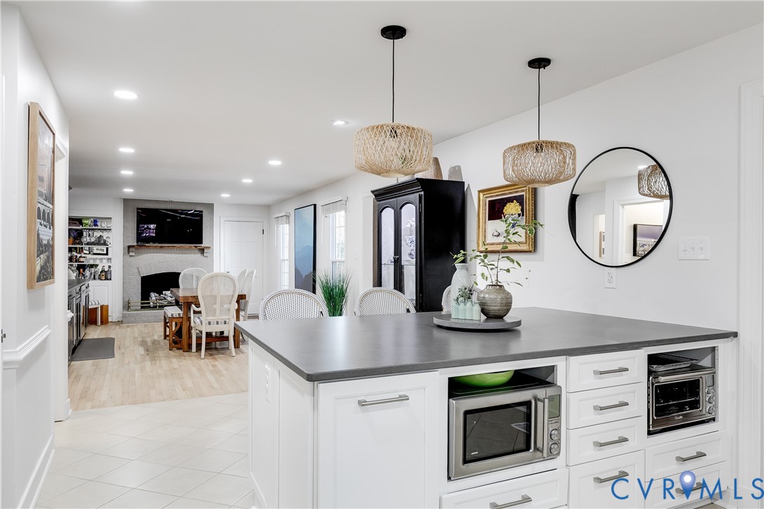3150 East Brigstock Road Midlothian, VA 23113 - Photo 12 of 50 a kitchen with stainless steel appliances a stove a microwave a dining table chairs and chandelier