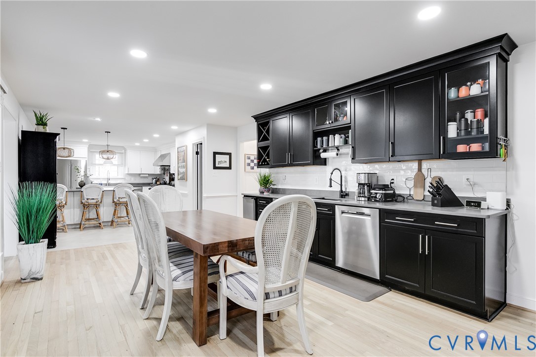 3150 East Brigstock Road Midlothian, VA 23113 - Photo 17 of 50 a kitchen with stainless steel appliances kitchen island granite countertop a stove a sink a microwave a dining table and chairs