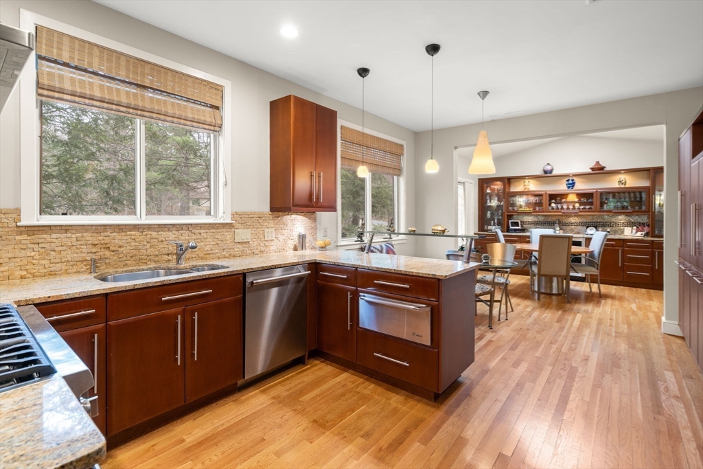 214 Allandale Road, Unit D Boston, MA 02467 - Photo 16 of 40 a kitchen with stainless steel appliances granite countertop wooden cabinets a sink and a large window