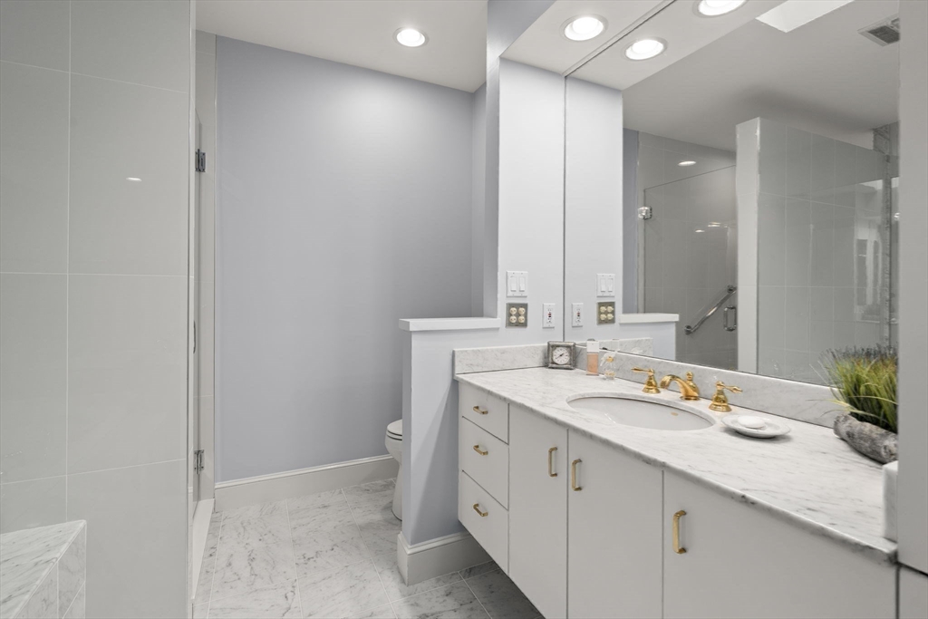 214 Allandale Road, Unit D Boston, MA 02467 - Photo 21 of 40 a bathroom with a sink a vanity and a mirror