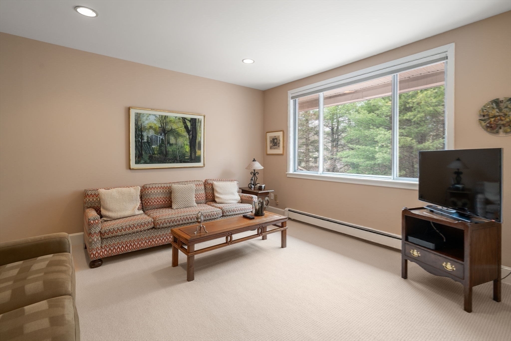 214 Allandale Road, Unit D Boston, MA 02467 - Photo 26 of 40 a living room with furniture a flat screen tv and a window