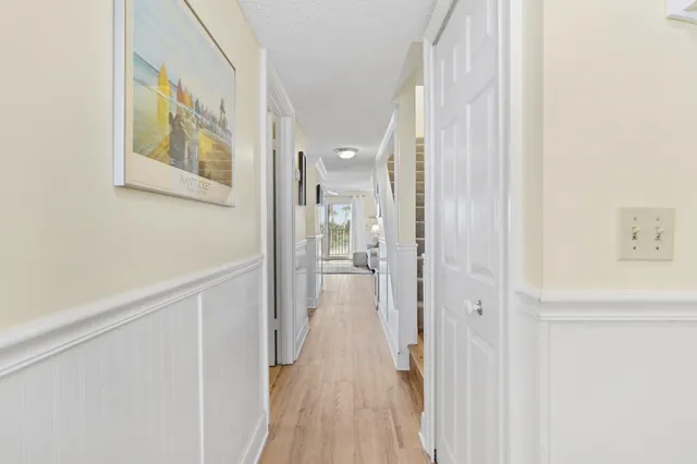 a view of a hallway with wooden floor and closet