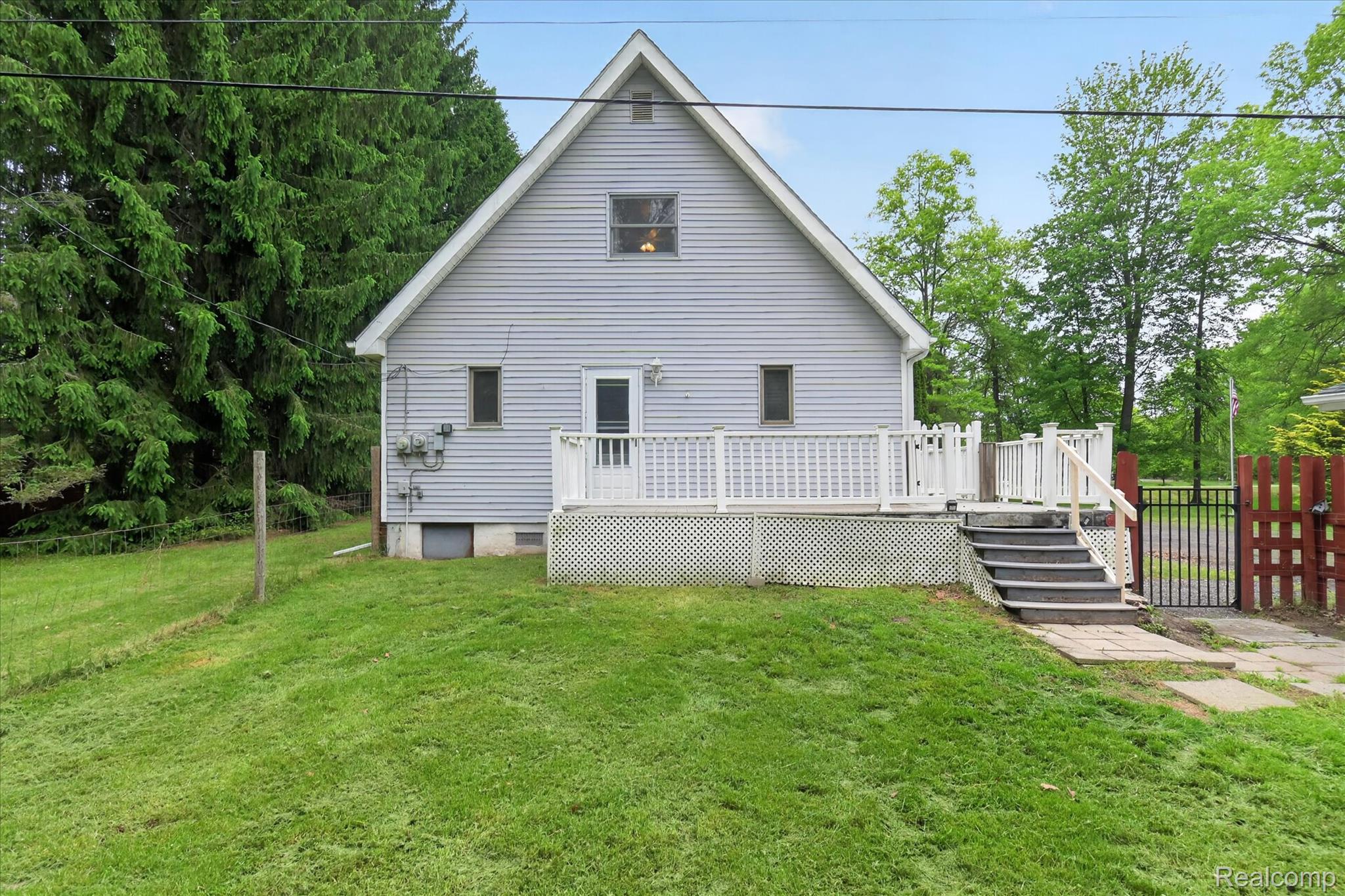 41303 Harris Road Belleville, MI 48111 - Photo 45 of 49 Rear view of house featuring a wooden deck and a lawn