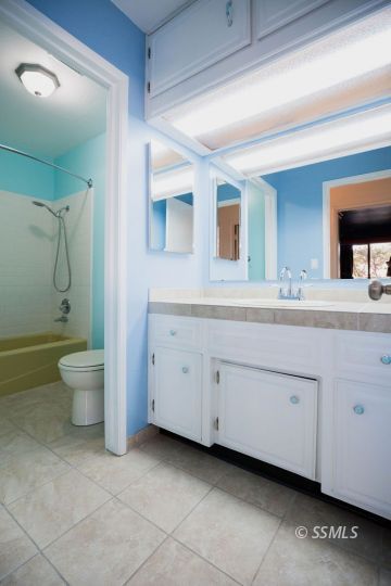 1025 Scott Street Ridgecrest, CA 93555 - Photo 21 of 29 a spacious bathroom with a double vanity sink a large mirror and toilet