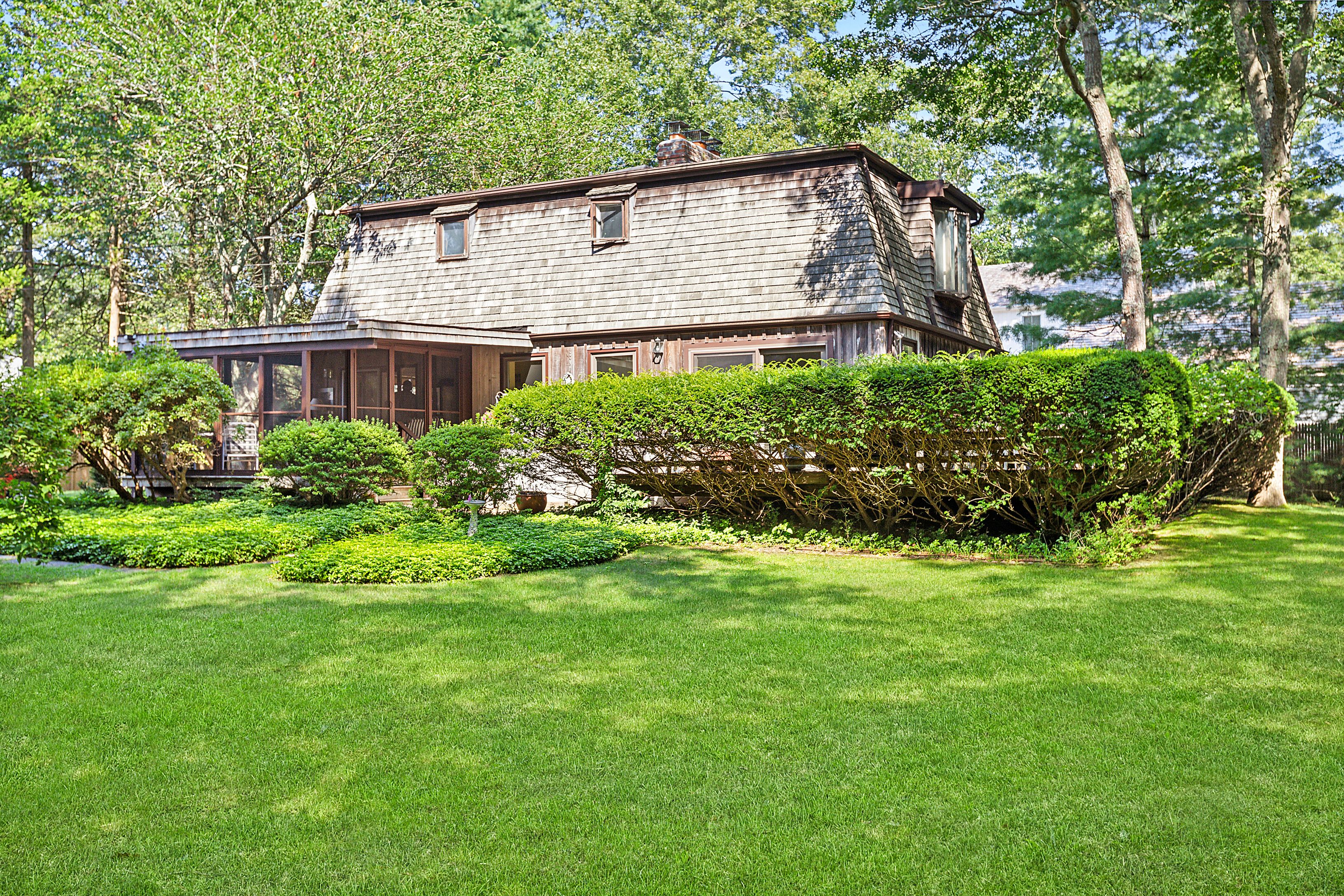 57 Wireless Road East Hampton, NY 11937 - Photo 24 of 27 a brick house with a big yard and large trees