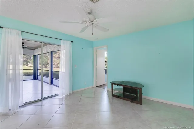 a view of an empty room with a chandelier fan