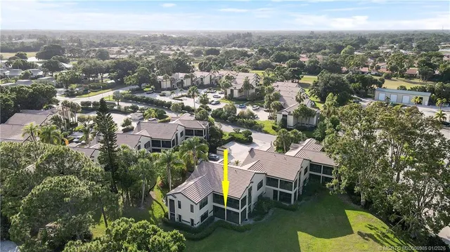 an aerial view of a house with outdoor space and trees all around