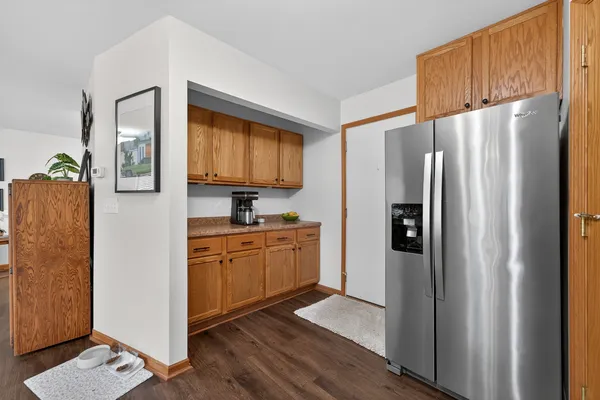 a kitchen with stainless steel appliances granite countertop a refrigerator a stove and a sink with wooden floor