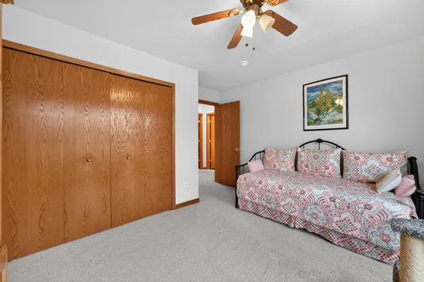 a spacious bedroom with a bed and a chandelier