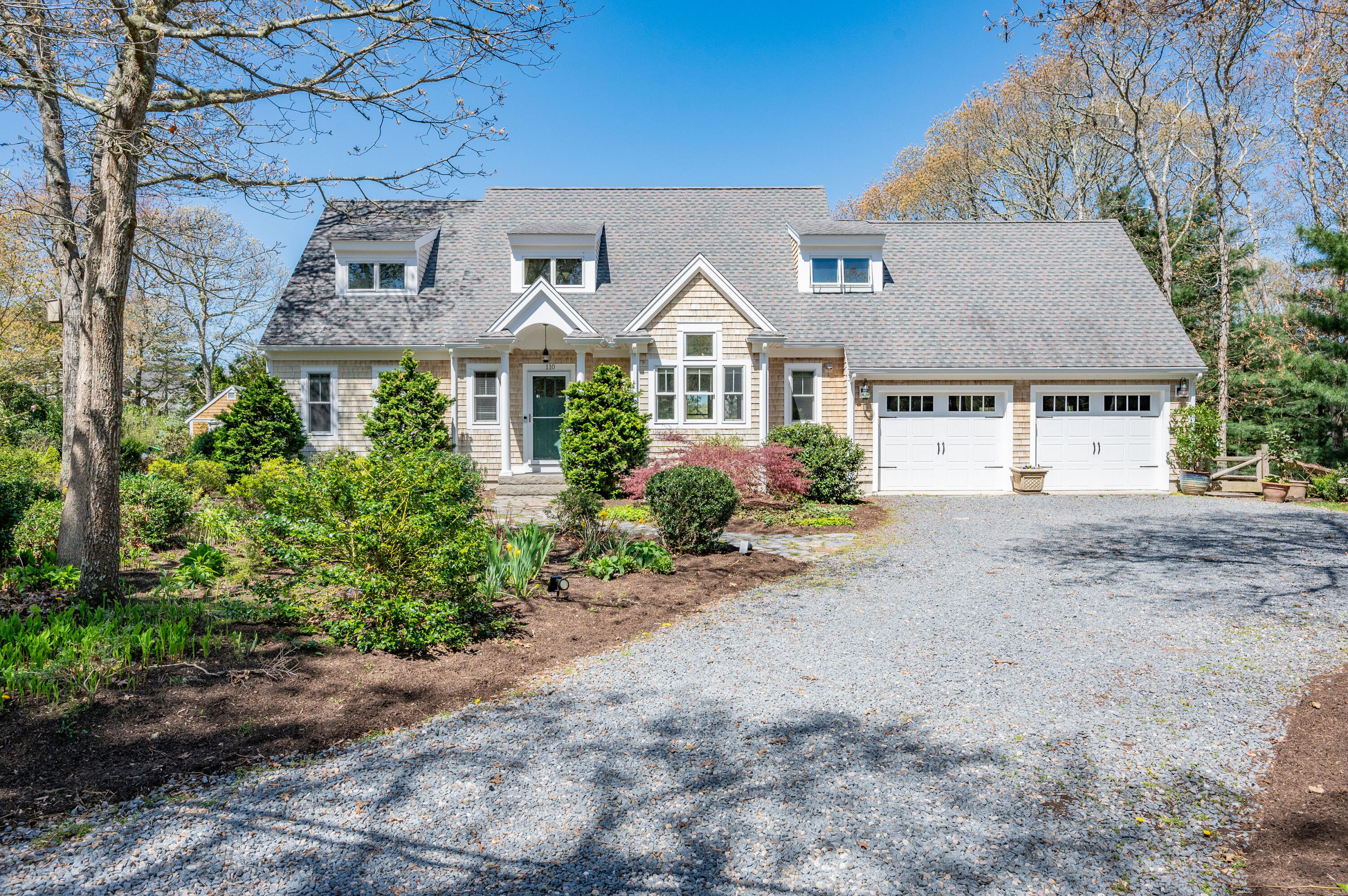 110 Clamshell Cove Road Cotuit, MA 02635 - Photo 1 of 56 a front view of a house with a garden
