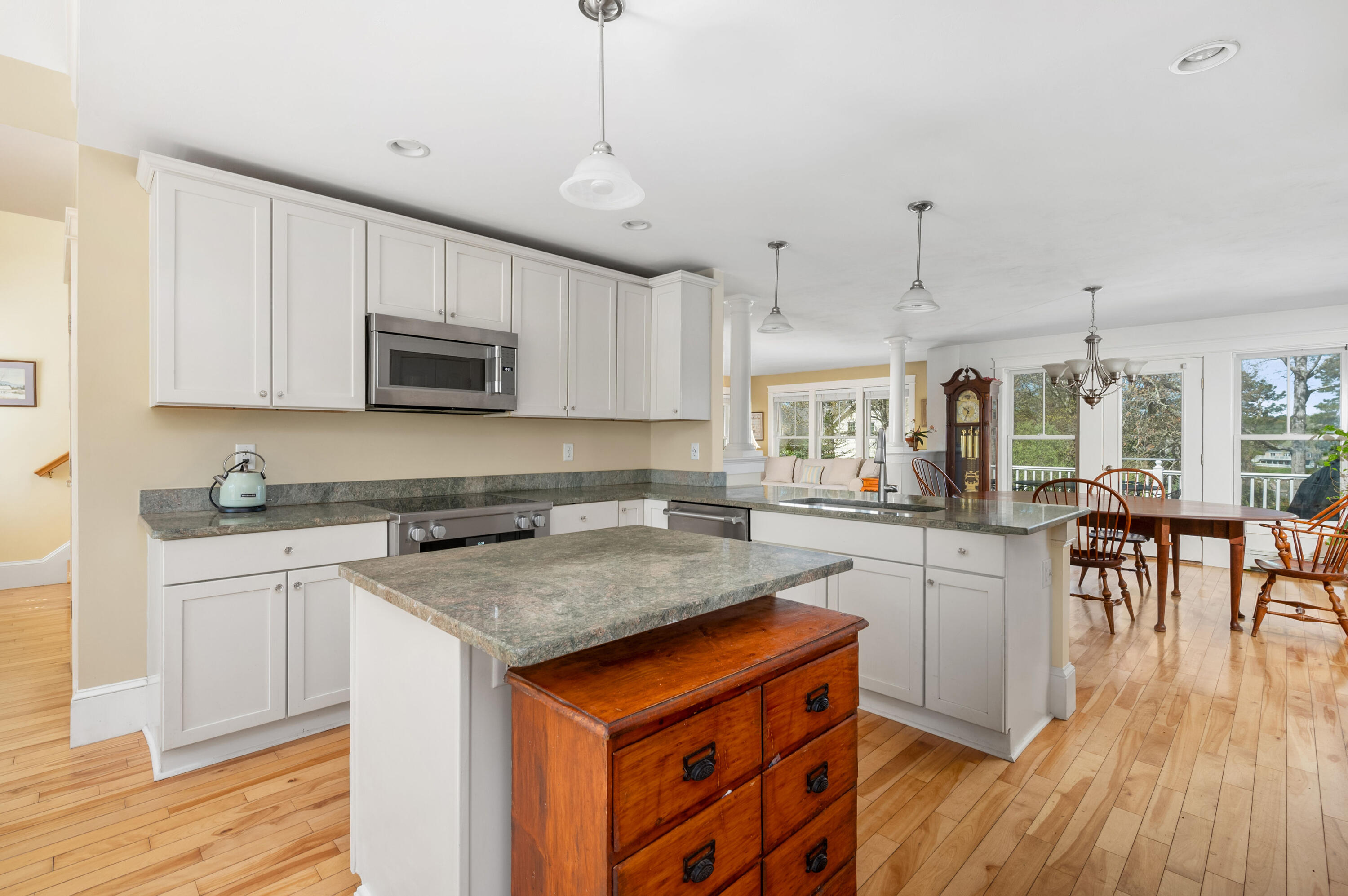 110 Clamshell Cove Road Cotuit, MA 02635 - Photo 12 of 56 a kitchen with stainless steel appliances granite countertop a stove a sink dishwasher a microwave oven and a dining table with wooden floor