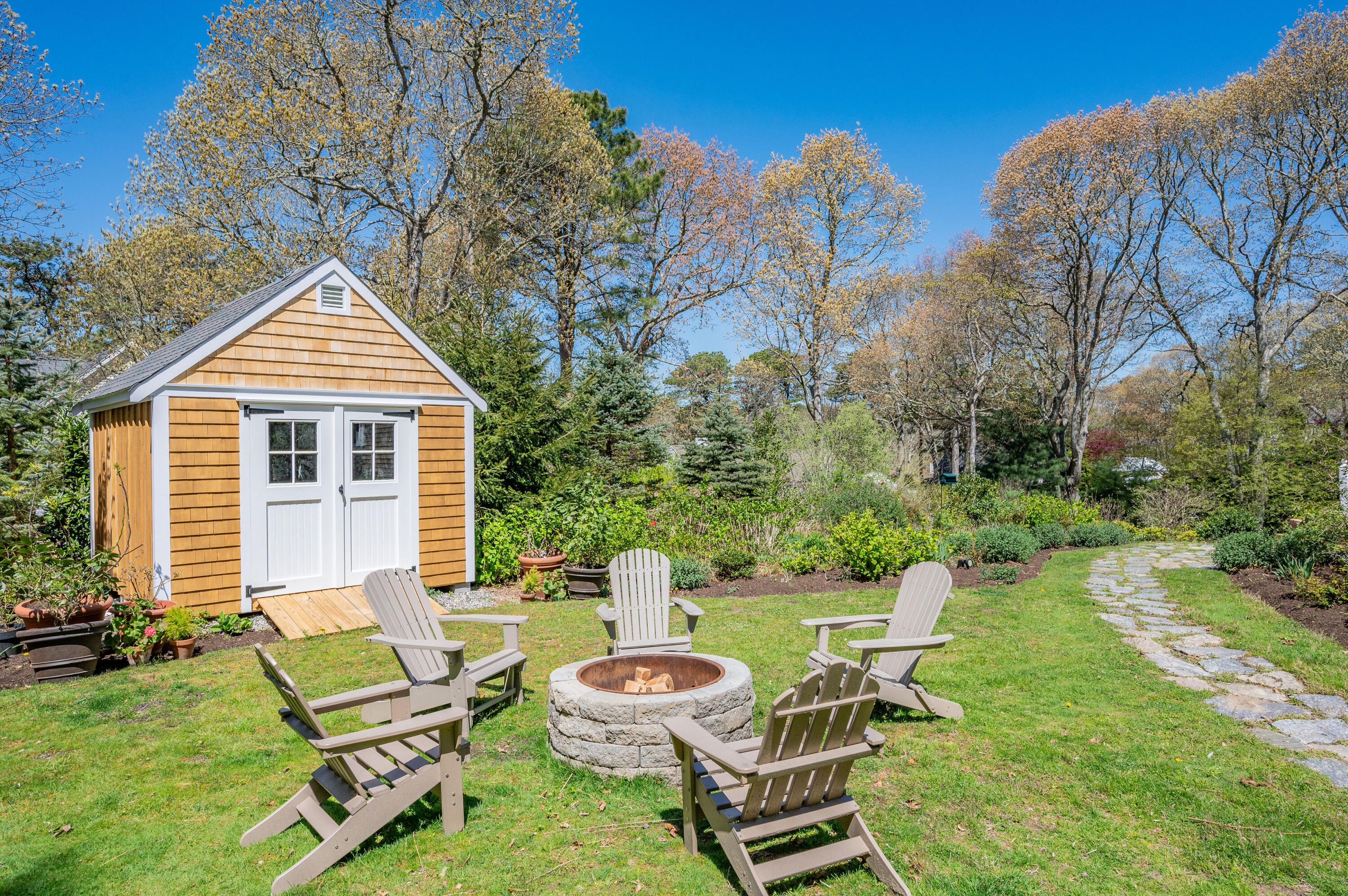 110 Clamshell Cove Road Cotuit, MA 02635 - Photo 5 of 56 a view of a chair and tables in the backyard