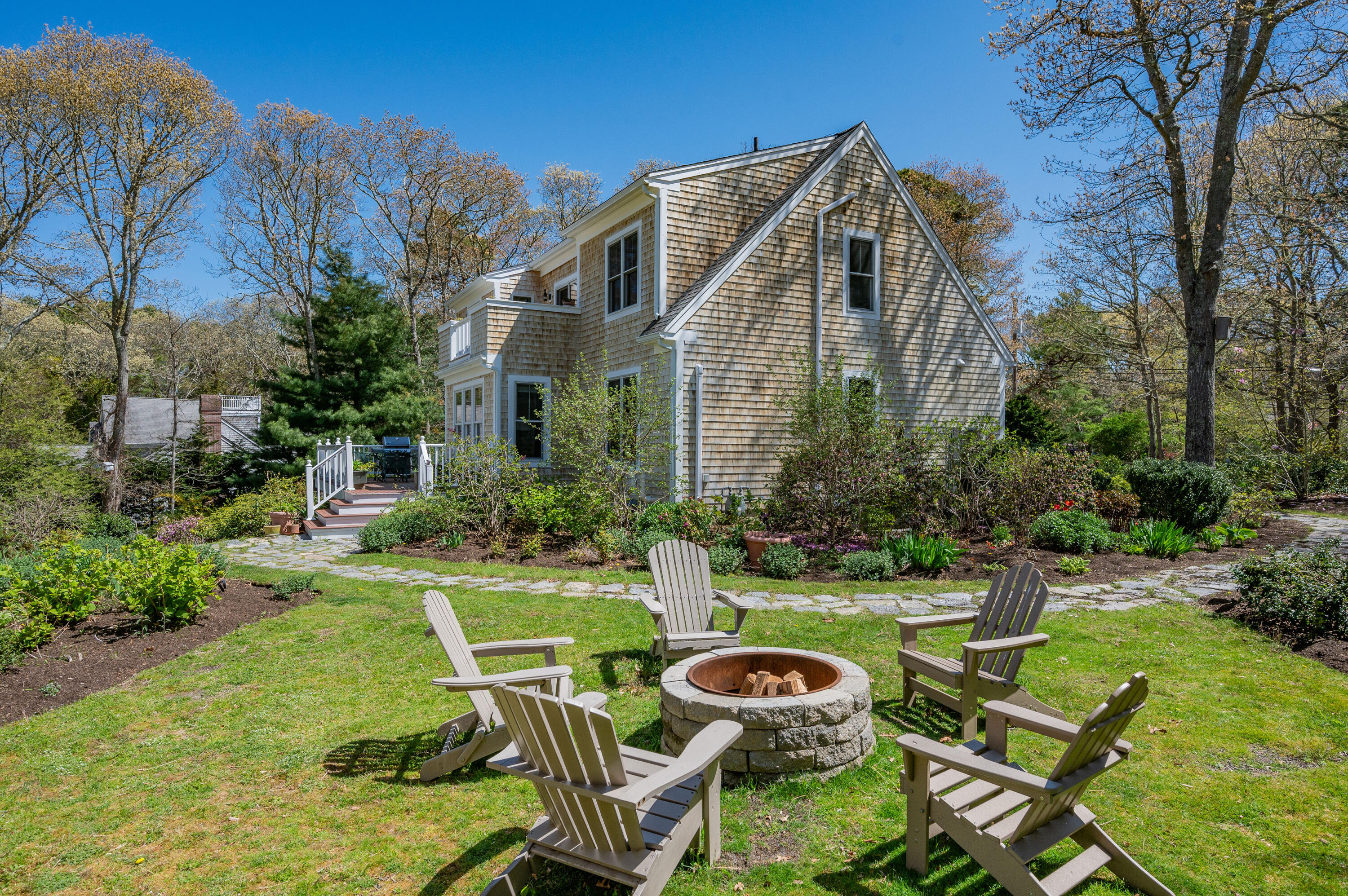 110 Clamshell Cove Road Cotuit, MA 02635 - Photo 54 of 56 a view of a chair and table in backyard of the house
