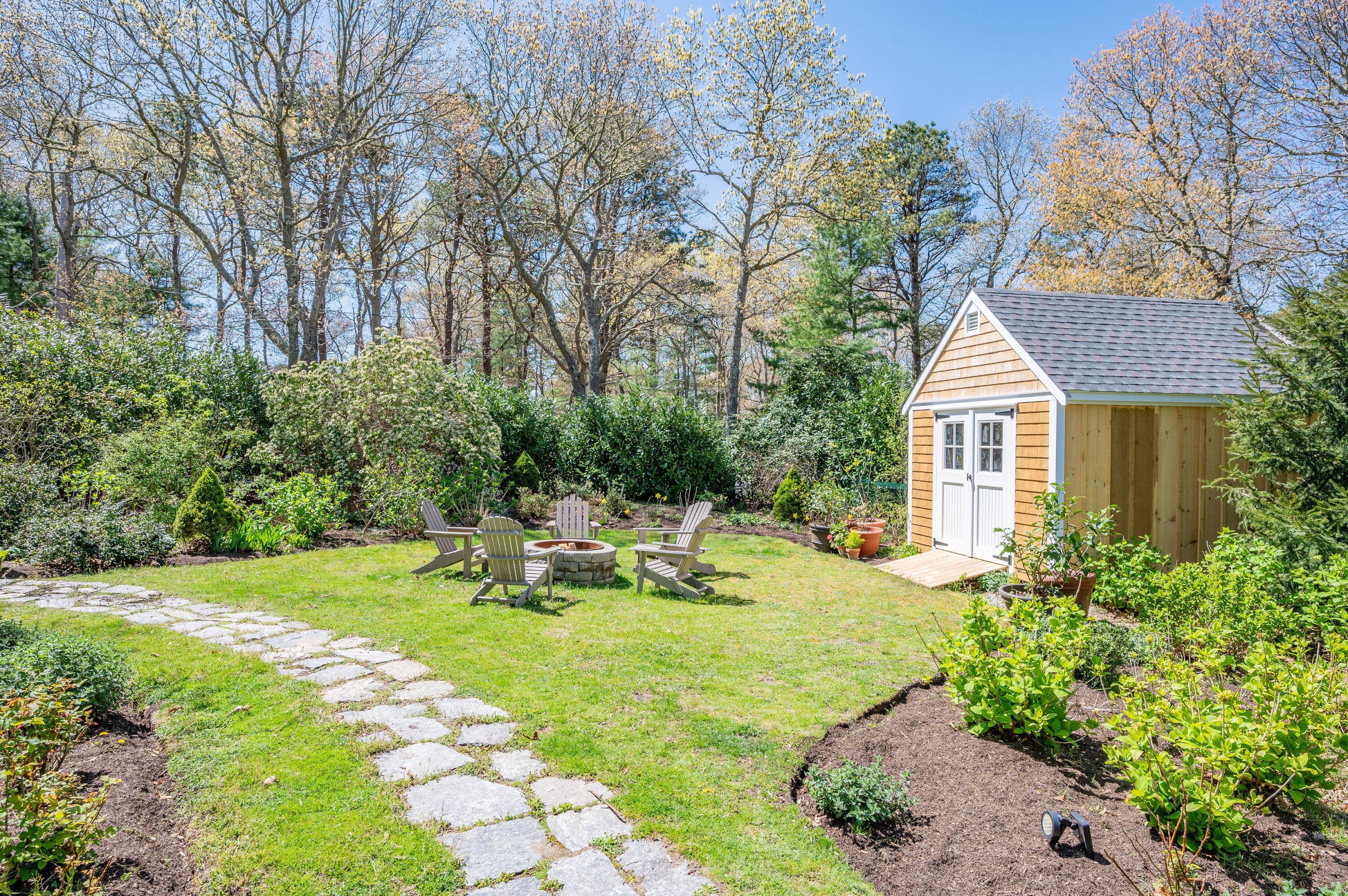 110 Clamshell Cove Road Cotuit, MA 02635 - Photo 55 of 56 a view of a house with a yard patio and fire pit