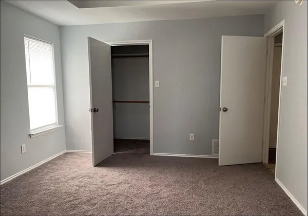 an empty room with windows and closet