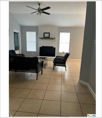 a living room with a black white checkered floor with a fireplace and a large window