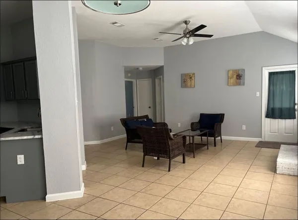 a dining room with furniture and a chandelier fan