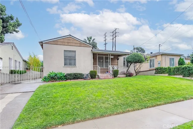 a front view of a house with a yard and trees