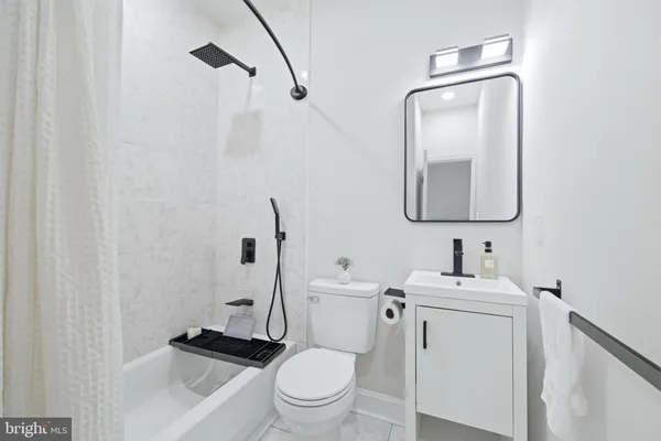 a white toilet sitting next to a shower