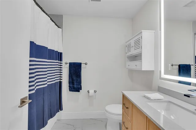 a patio with table and chairs and potted plants