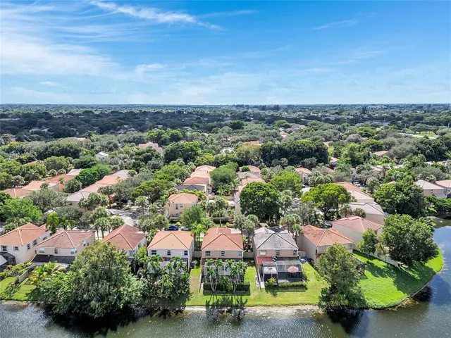 an aerial view of residential houses with outdoor space and lake view