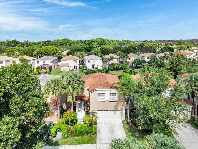 an aerial view of residential houses with outdoor space and trees