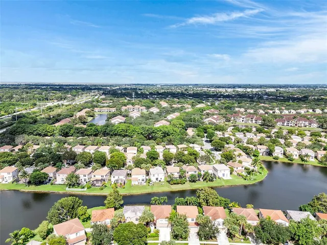 an aerial view of green landscape with trees houses and yard