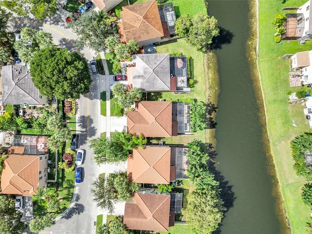 an aerial view of residential houses with outdoor space and trees