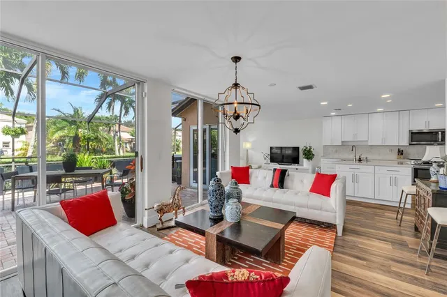a living room with furniture kitchen view and large windows
