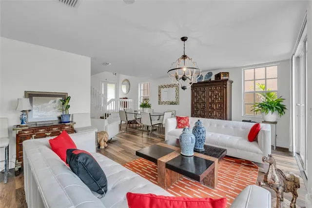 a living room with furniture a chandelier and a window