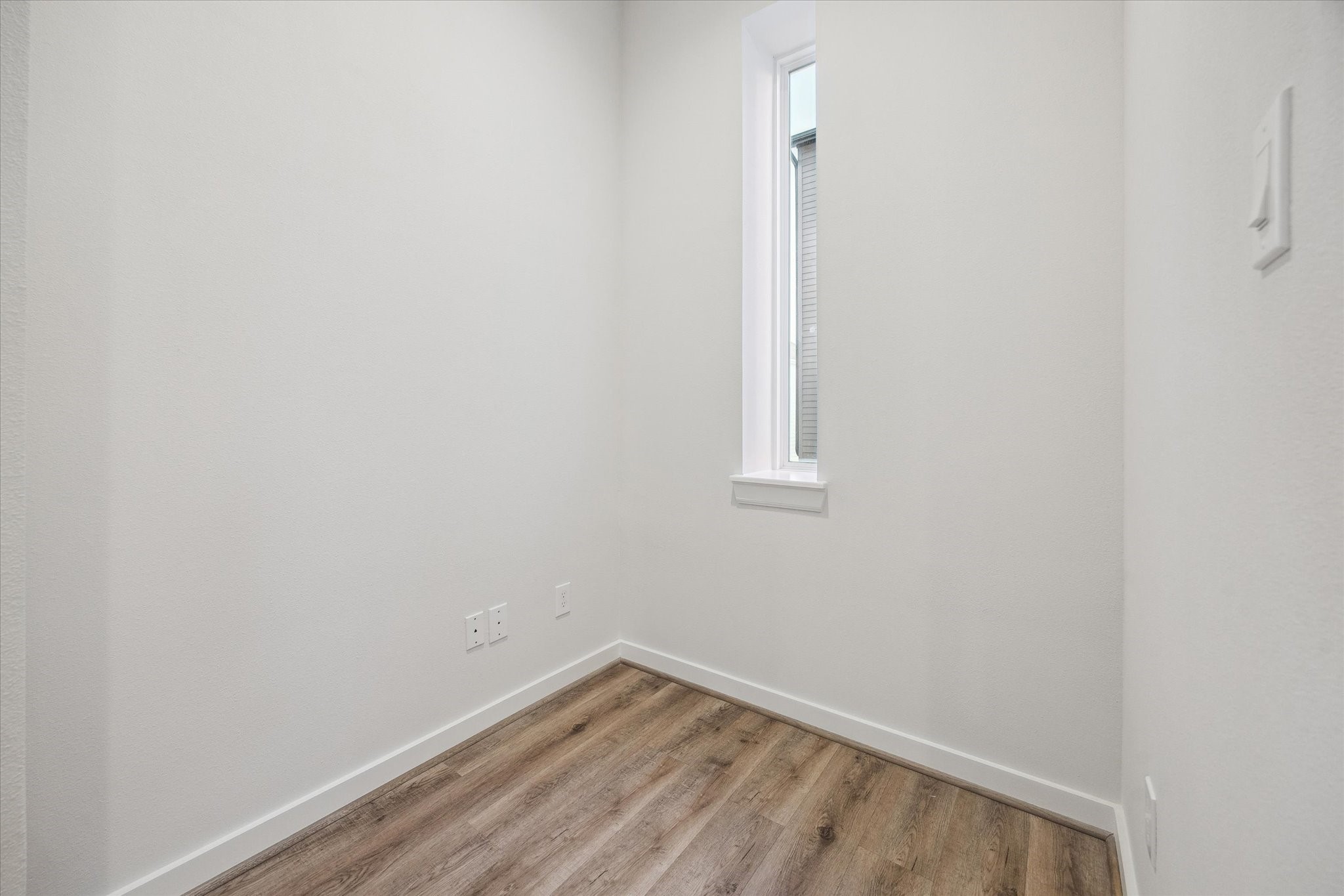 1603 Patterson Street, Unit E Houston, TX 77007 - Photo 20 of 32 This photo features a small, bright room with light walls. . A tall, narrow window allows natural light to enter, making it ideal for a cozy office or reading nook.