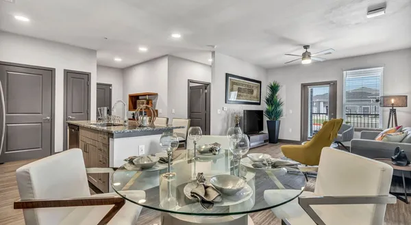 a dining room with furniture a kitchen view and wooden floor