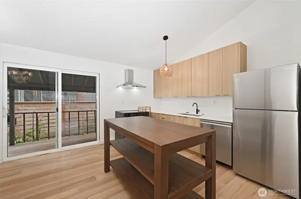 a kitchen with a refrigerator a sink and wooden floor