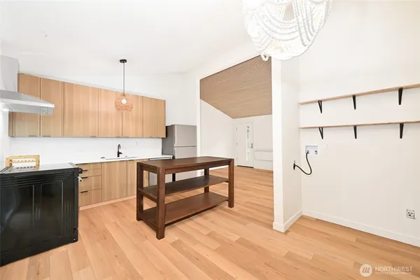 a kitchen with stainless steel appliances granite countertop a refrigerator a sink and a stove