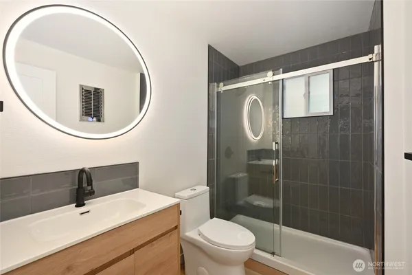 a bathroom with a sink a toilet and shower