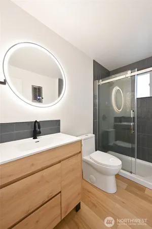 a bathroom with a sink a toilet and shower