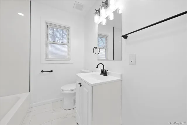 a bathroom with a toilet a sink and mirror