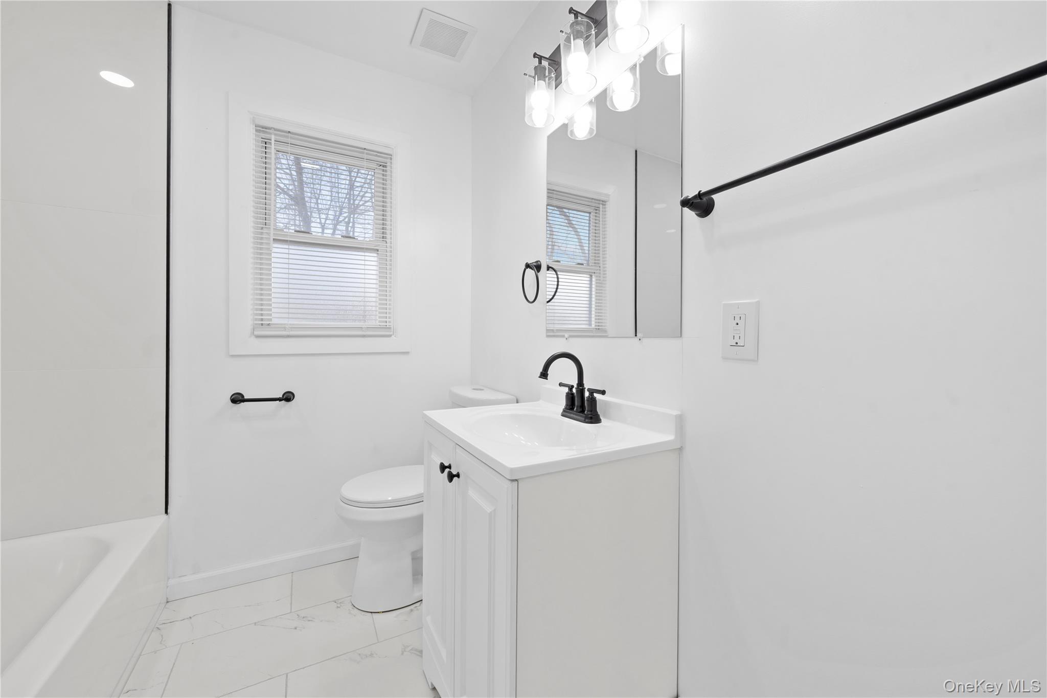 193 North Arizona Road West Babylon, NY 11704 - Photo 16 of 37 a bathroom with a toilet a sink and mirror