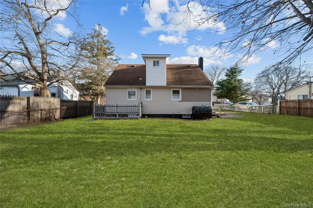 a view of a house with a big yard and large trees