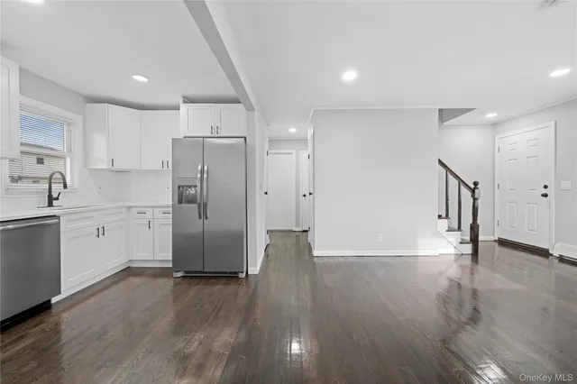 a view of a kitchen with wooden floor and electronic appliances