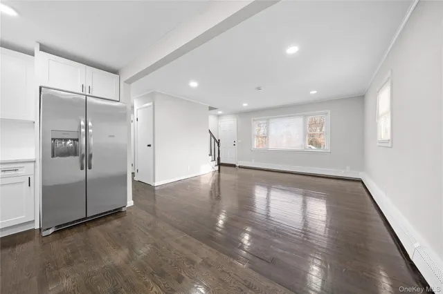 a view of empty room with wooden floor and window
